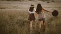twee meisjes wandelen in het gras (type vriendin)