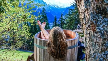 vrouw in bad in natuur (dit is jouw beste selfcare-moment volgens je sterrenbeeld)