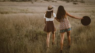 twee meisjes wandelen in het gras (type vriendin)